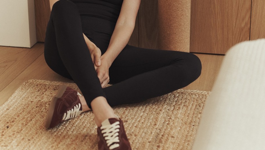 close up of woman in black leggings sitting on floor