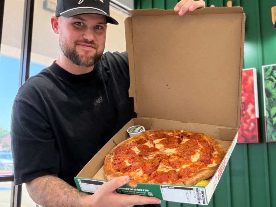 man holding open box of papa john's pizza