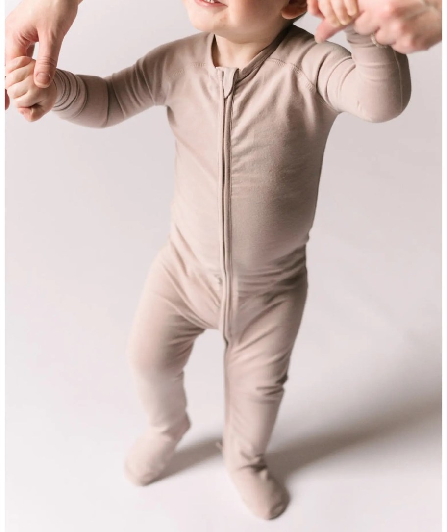 baby wearing light pink footie pajamas