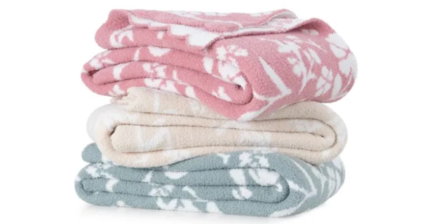pink, tan,a nd blue floral blankets stacked 