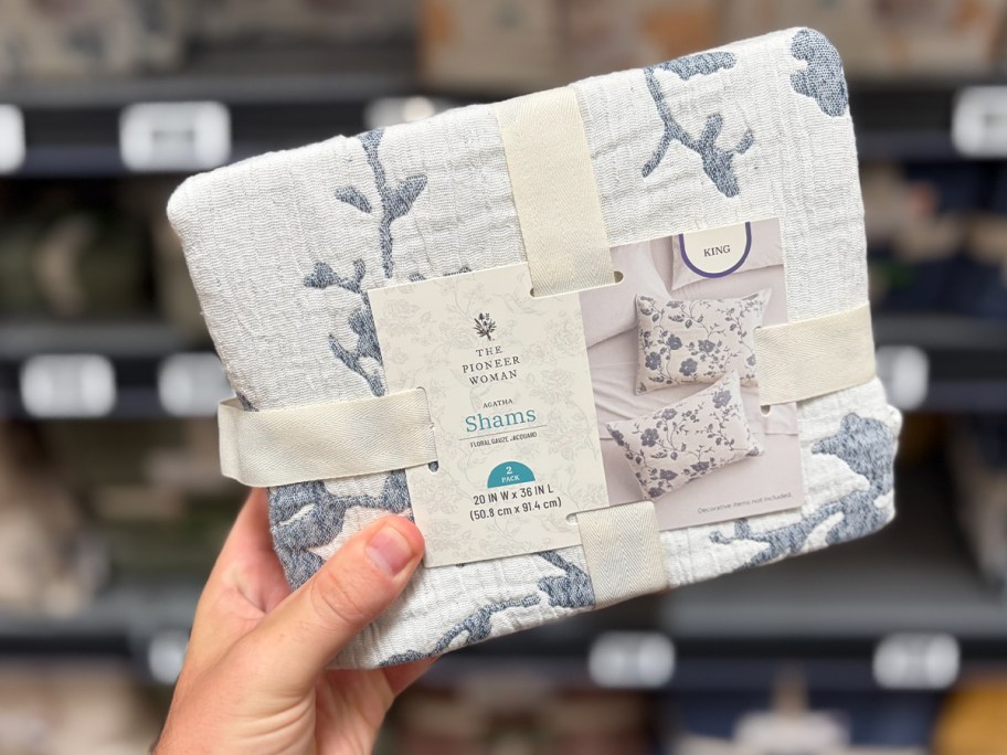 hand holding blue floral shams pack