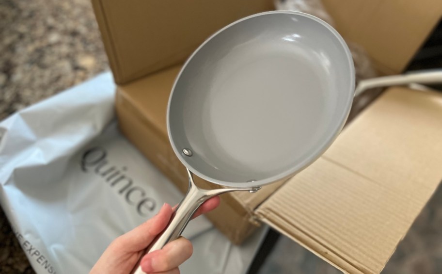 hand holding quince saute pan over box