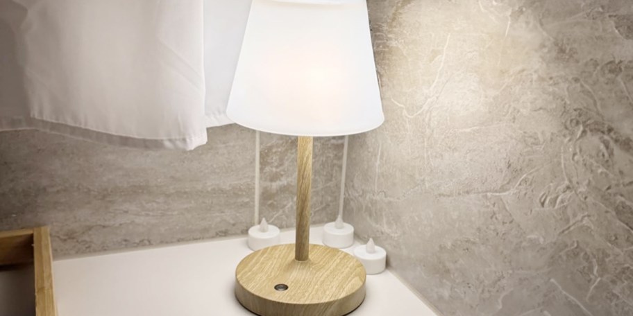 white and wood lamp on bathtub