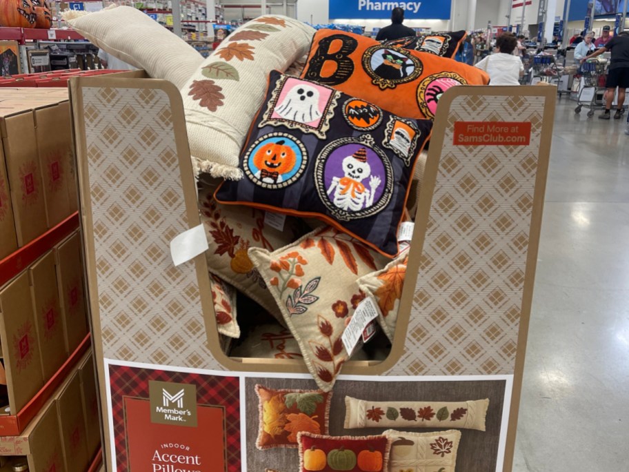 Member's Mark fall and Halloween-themed accent pillows displayed in a cardboard bin at Sam's Club.