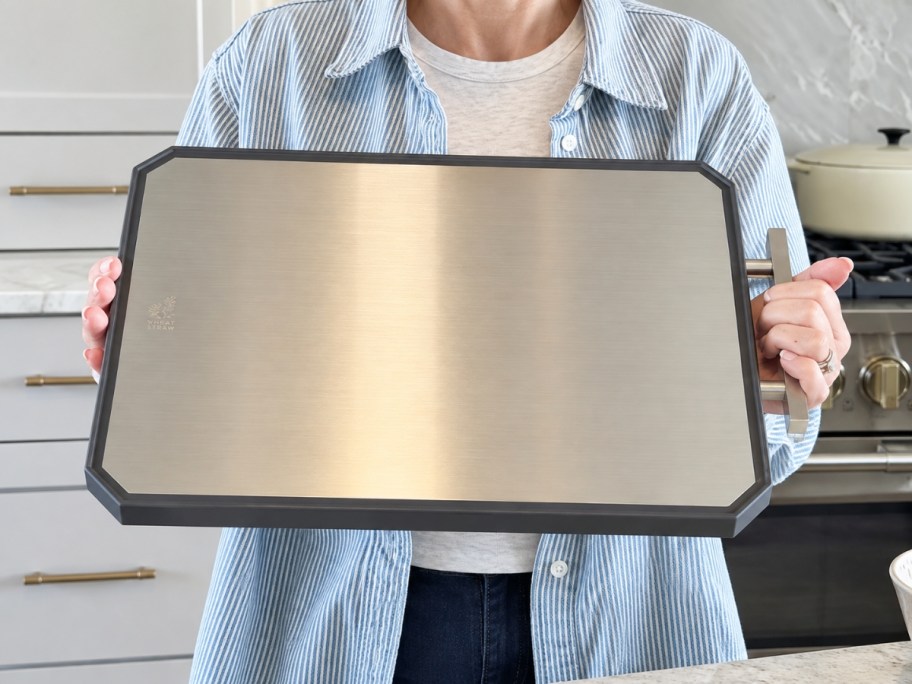 woman holding a dual sided cutting board