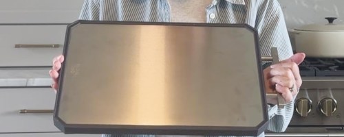 person holding stainless steel cutting board