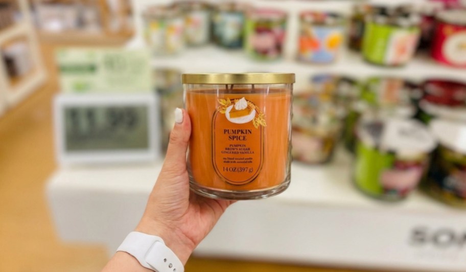 hand holding pumpkin spice candle in store