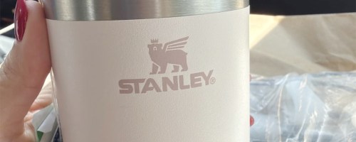 hand holding stanley white cup