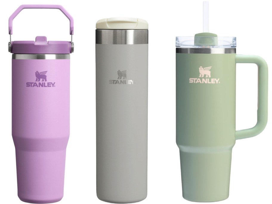 Three Stanley tumblers in purple, grey, and green.