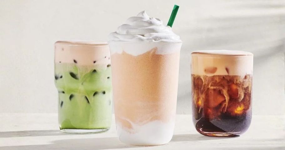three starbucks orange cream drinks on table
