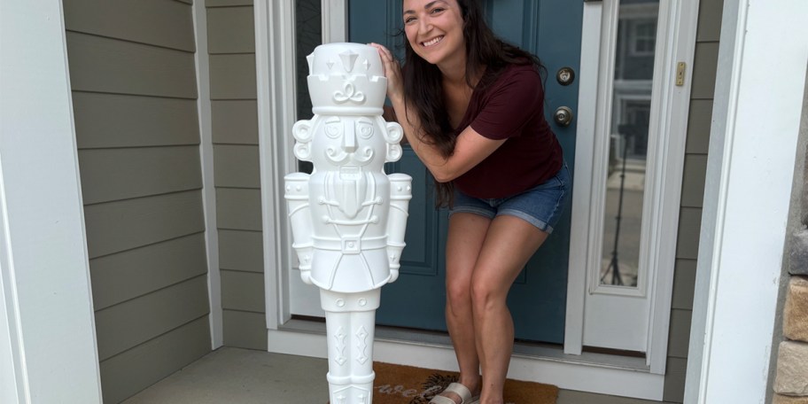 woman standing next to paintable nutcracker 