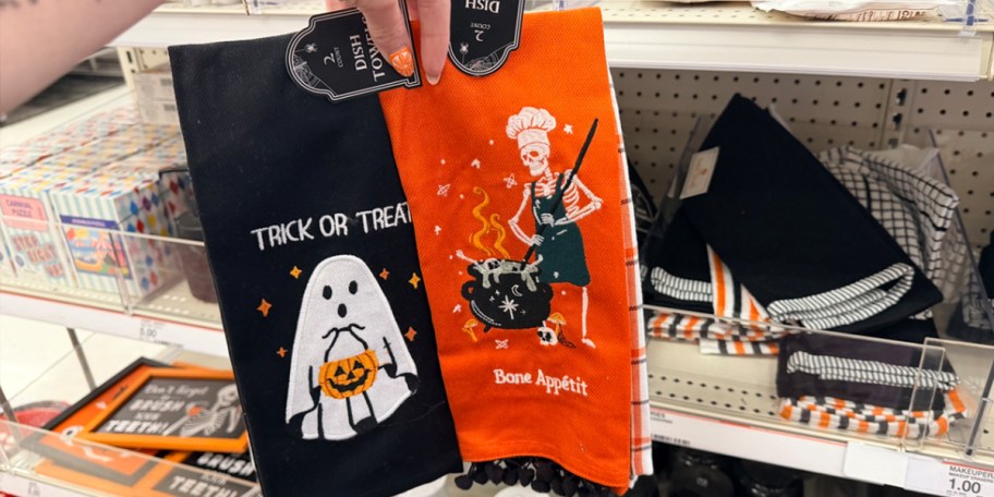 hand holding black and orange dish towels 