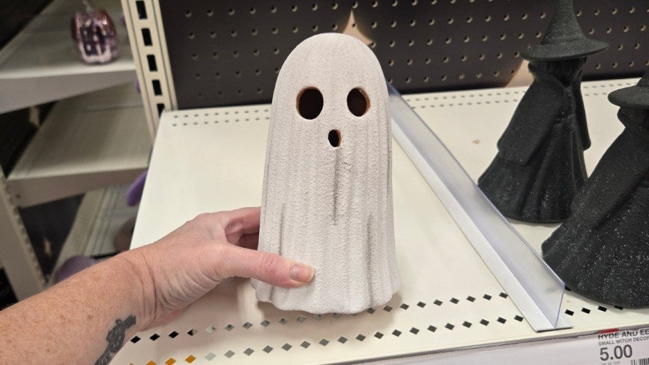 womans hand holding a white ghost figure
