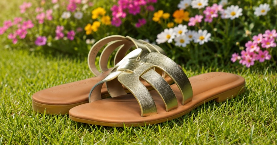 a pair of gold and tan sandals in the grass