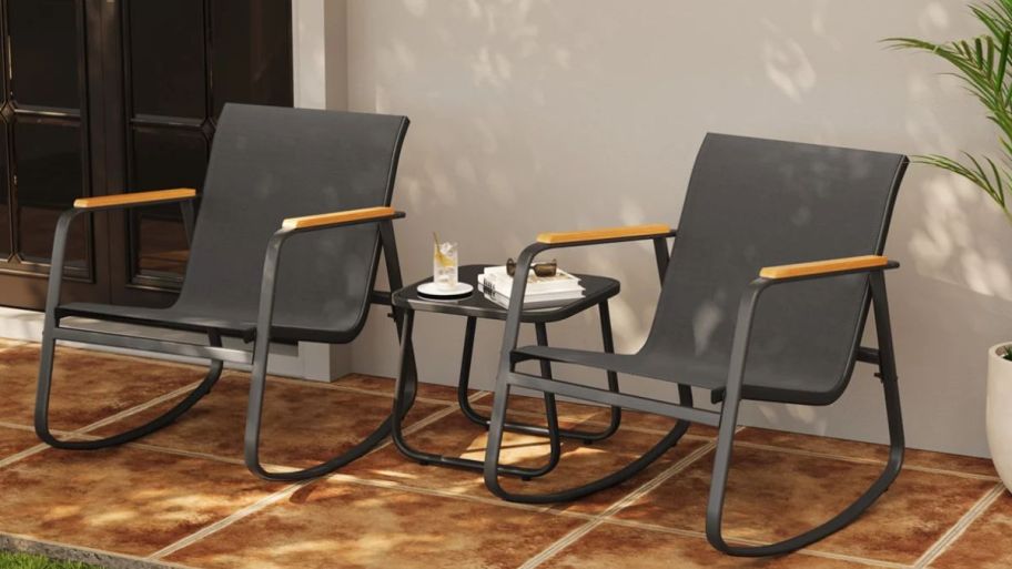 three piece rocking chairs with table displayed on the side of the house