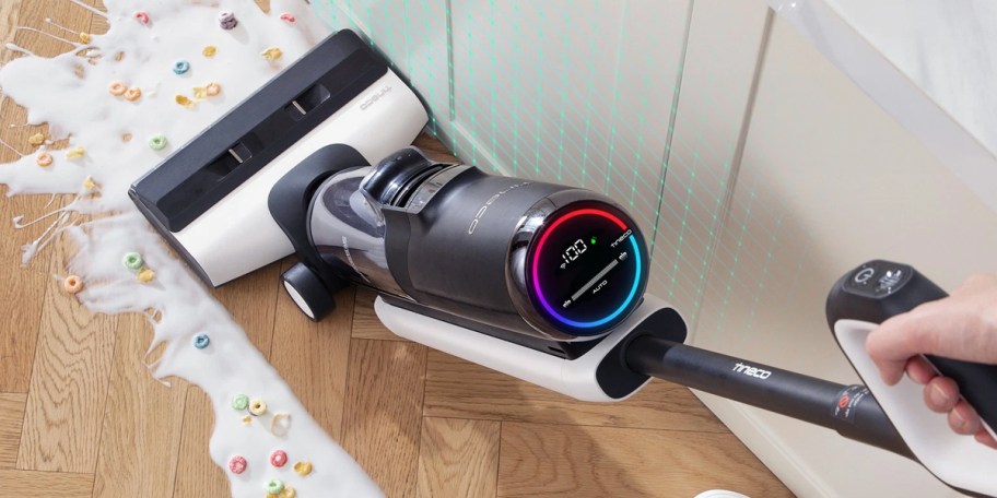 person using vacuum to clean up spilled cereal