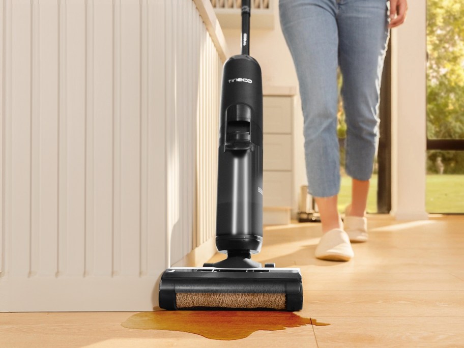 person using vacuum to clean up spilled drink