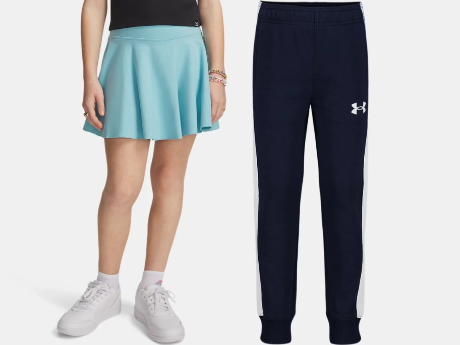 A person wearing a light blue athletic skirt and white sneakers next to a pair of navy blue Under Armour sweatpants with white side stripes.