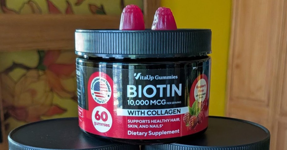 container of biotin gummies with two gummies on top of the container