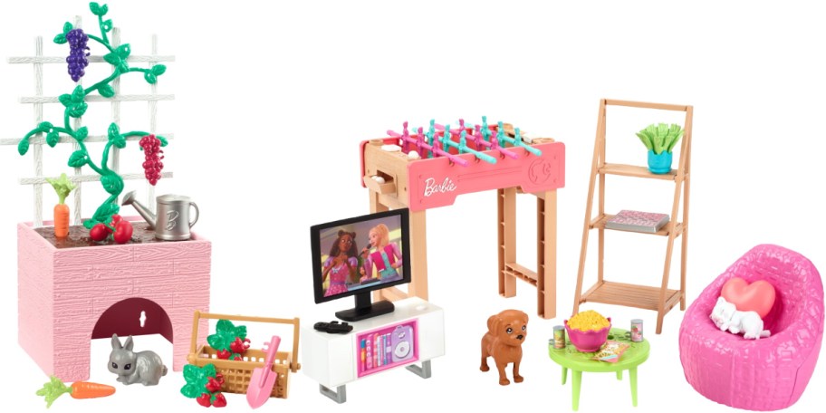 A Barbie playset collection featuring a garden planter box with a rabbit, a TV console, a pink foosball table, a toy dog, a shelving unit, a small table with snacks, and a pink beanbag chair with a white cat.