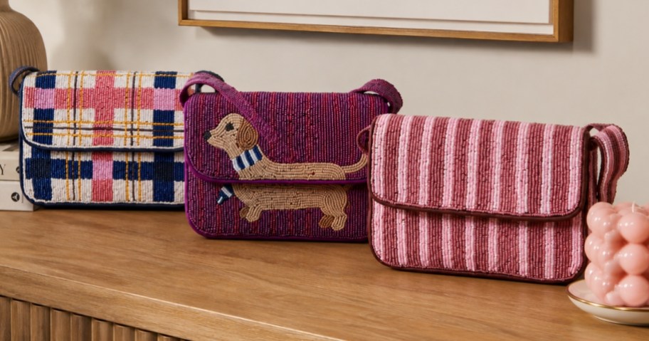 three beaded hand bags on a console table