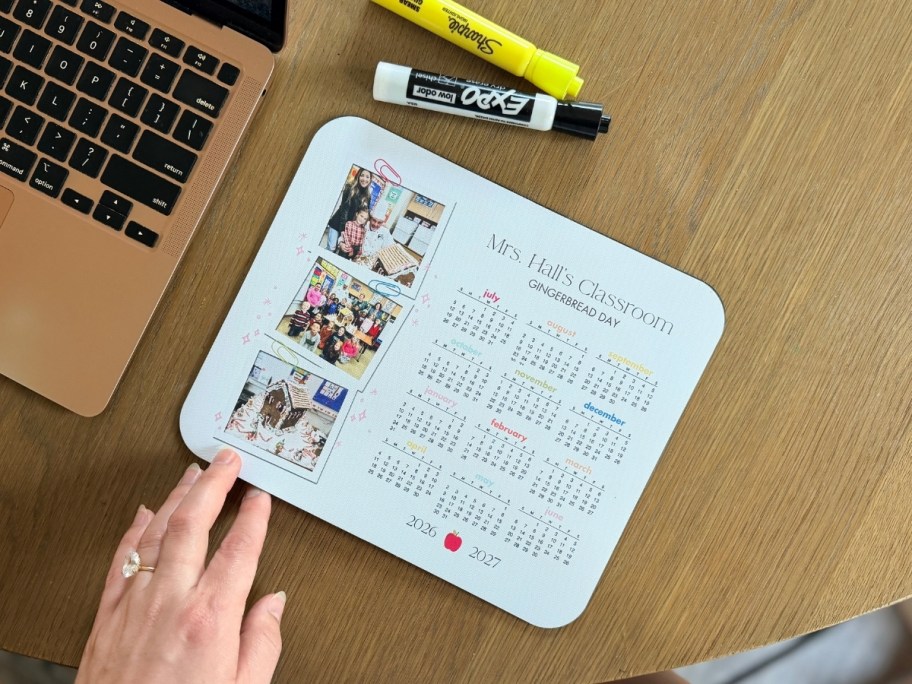 a mouse pad on a table top next to a laptop