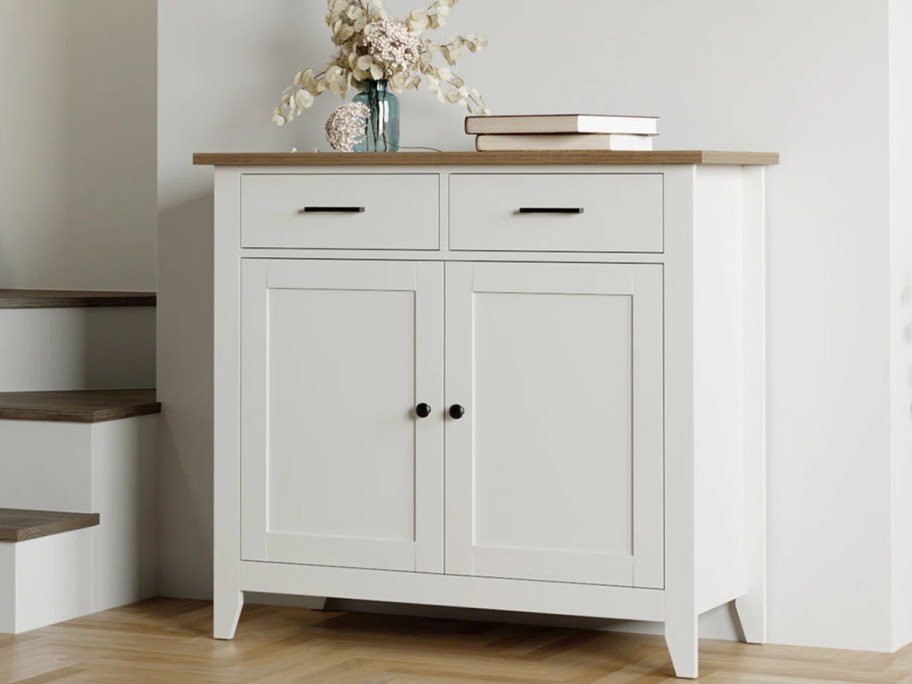 white cabinet with flowers and books on top 