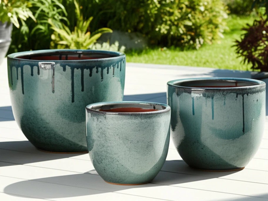three green planters on porch