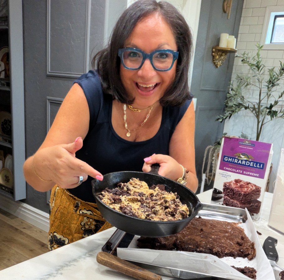 woman holding a skillet cookie in a cast iron skillet