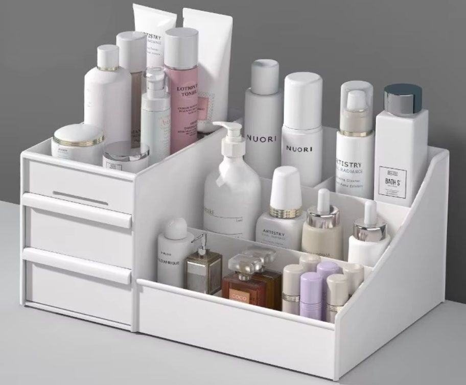 A white plastic makeup organizer with two drawers and multiple shelves