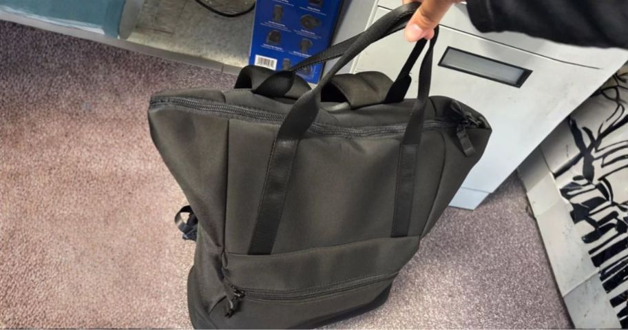 hand holding black All In Motion Faux Neoprene Tote Backpack