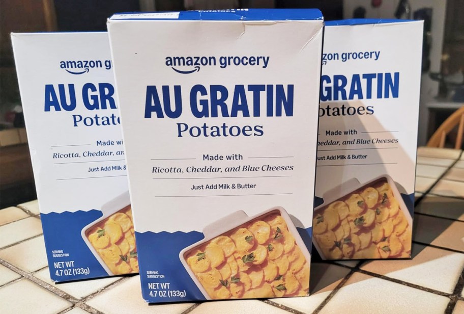 three boxes of Amazon Grocery Au Gratin Potatoes on a kitchen counter
