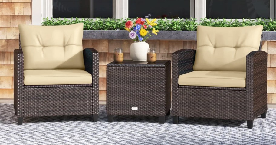 brown wicker chairs with tan cushions and matching side table