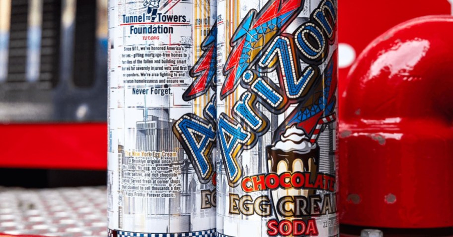 AriZona Chocolate Egg Cream Soda cans featuring a New York city theme, the Tunnel to Towers Foundation logo, and a graphic of a chocolate drink with whipped cream.
