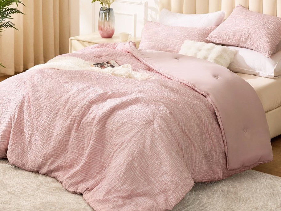 light pink comforter and pillowcases on a bed