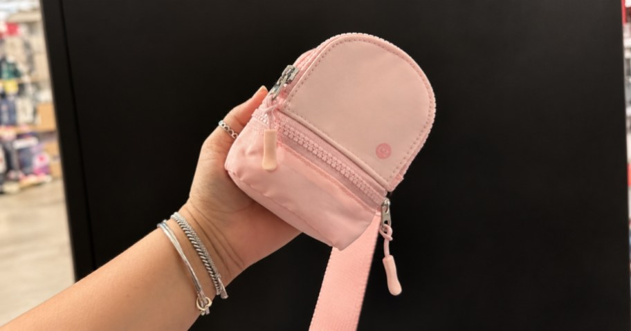 person holding pink mini backpack keychain wristlet