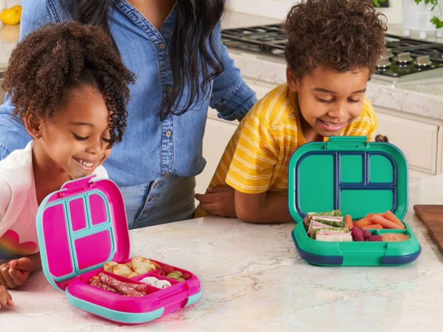 two kids looking at Bentgo Kids Chill Lunch Boxes in kitchen