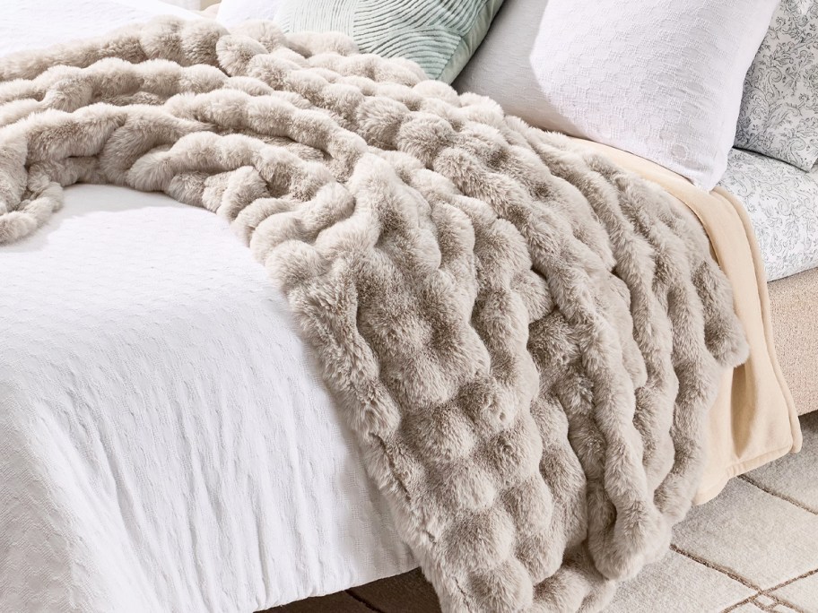 beige bubble throw draped over a bed