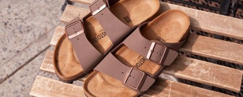 Birkenstock Taupe Arizona Sandals on a wooden slat table