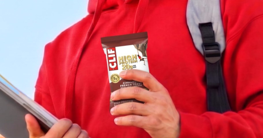 person holding clif high protein bar in cinnamon french toast flavor