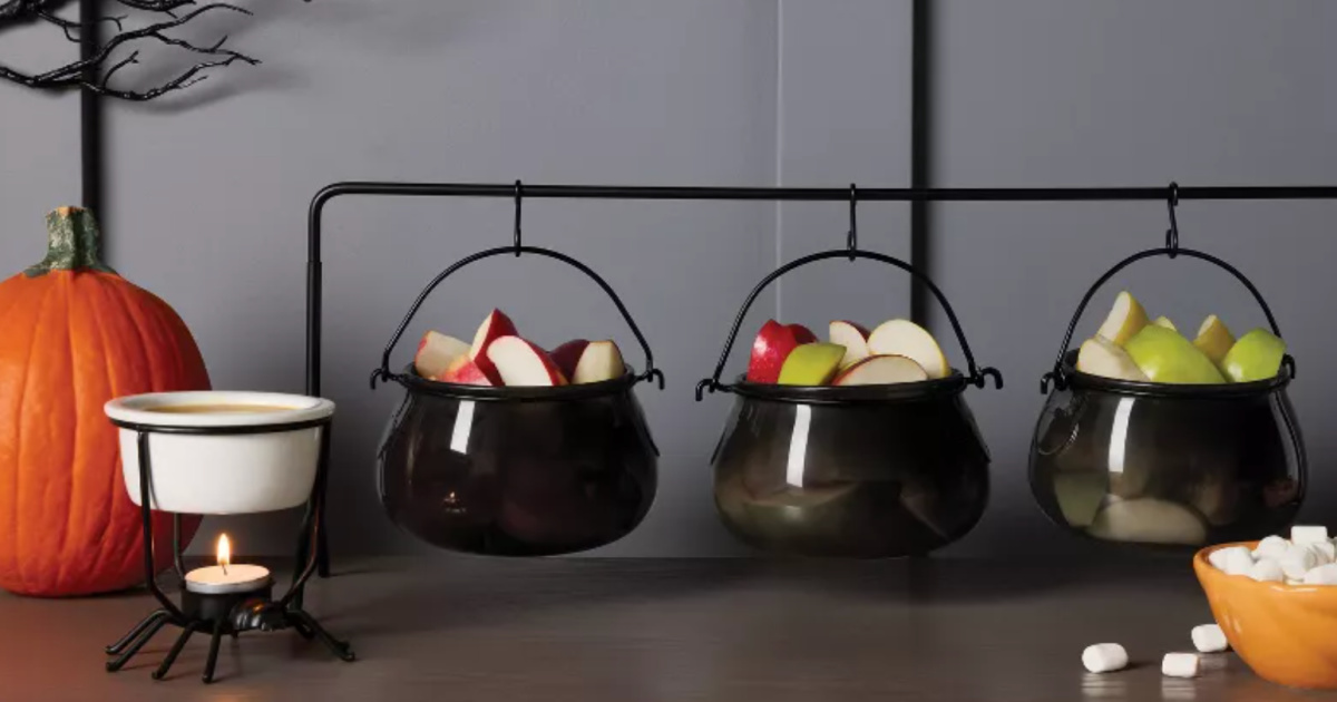Three piece black cauldron set filled with sliced apples on table top