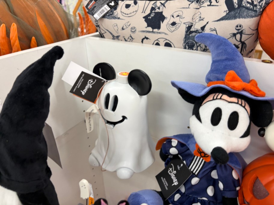 A Disney Halloween display featuring a white ghost figurine with Mickey Mouse ears next to a Minnie Mouse plush dressed in a blue witch hat and matching polka-dot outfit.