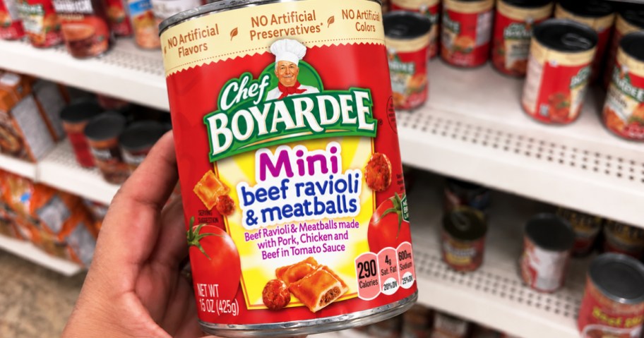 hand holding a can of Chef Boyardee in store aisle