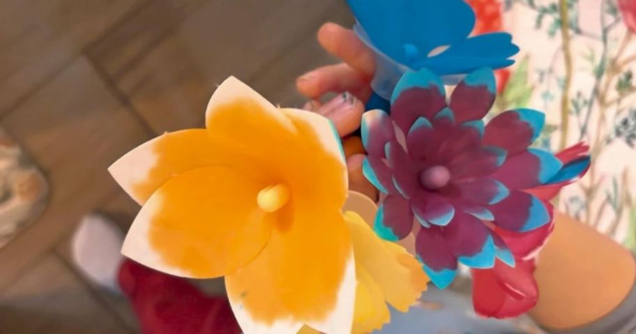 kid holding paper flowers