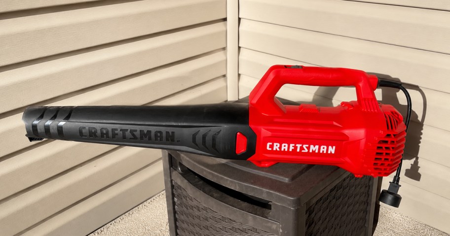 red and black Craftsman Corded Leaf Blower on top of a brown deck box