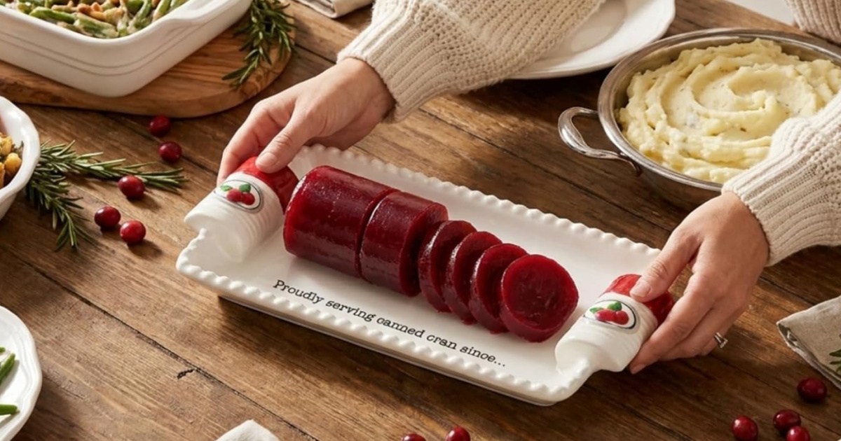 Person holding white ceramic cranberry dish and placing it on kitchen table