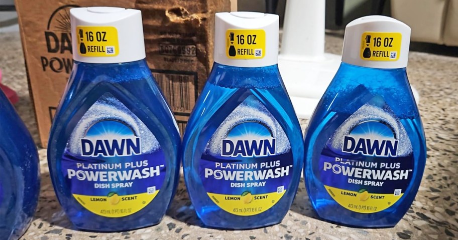 three blue bottles of dawn powerwash refills on a counter