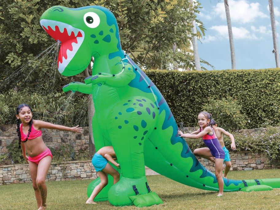 Extra large dino sprinkler with kids running around 