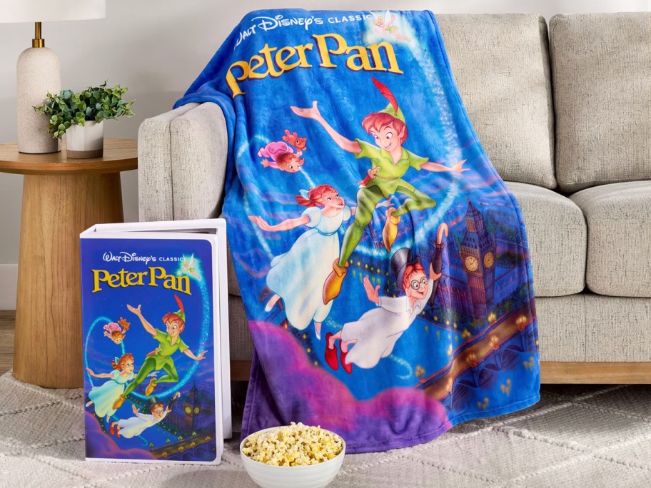 peter pan throw blanket draped over a sofa with a large vhs box in front of it