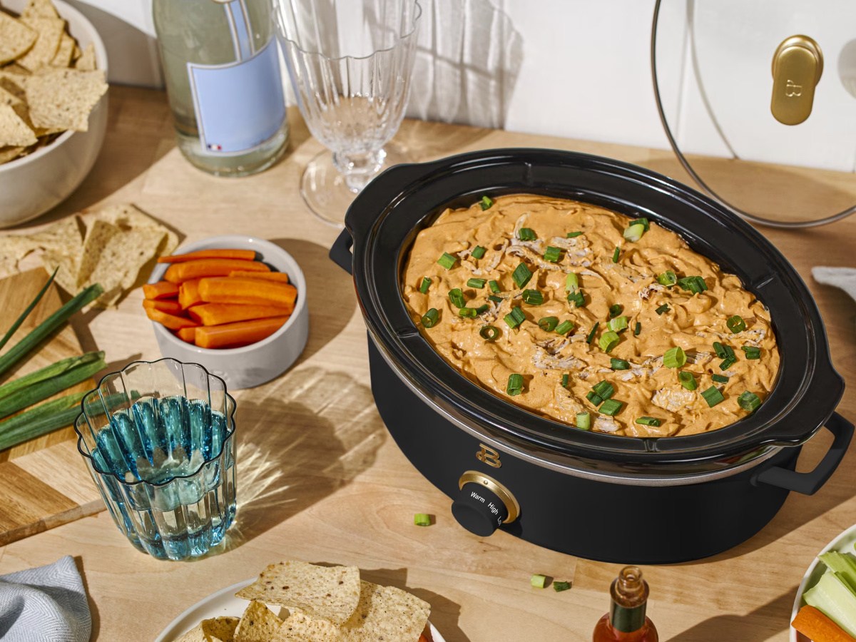 Black Drew Barrymore slow cooker filled with cheesy dip